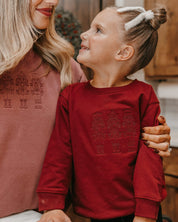 Child sweater in red with 3 embroidered nutcrackers on chest, shown on model – Little Mama Shirt Shop