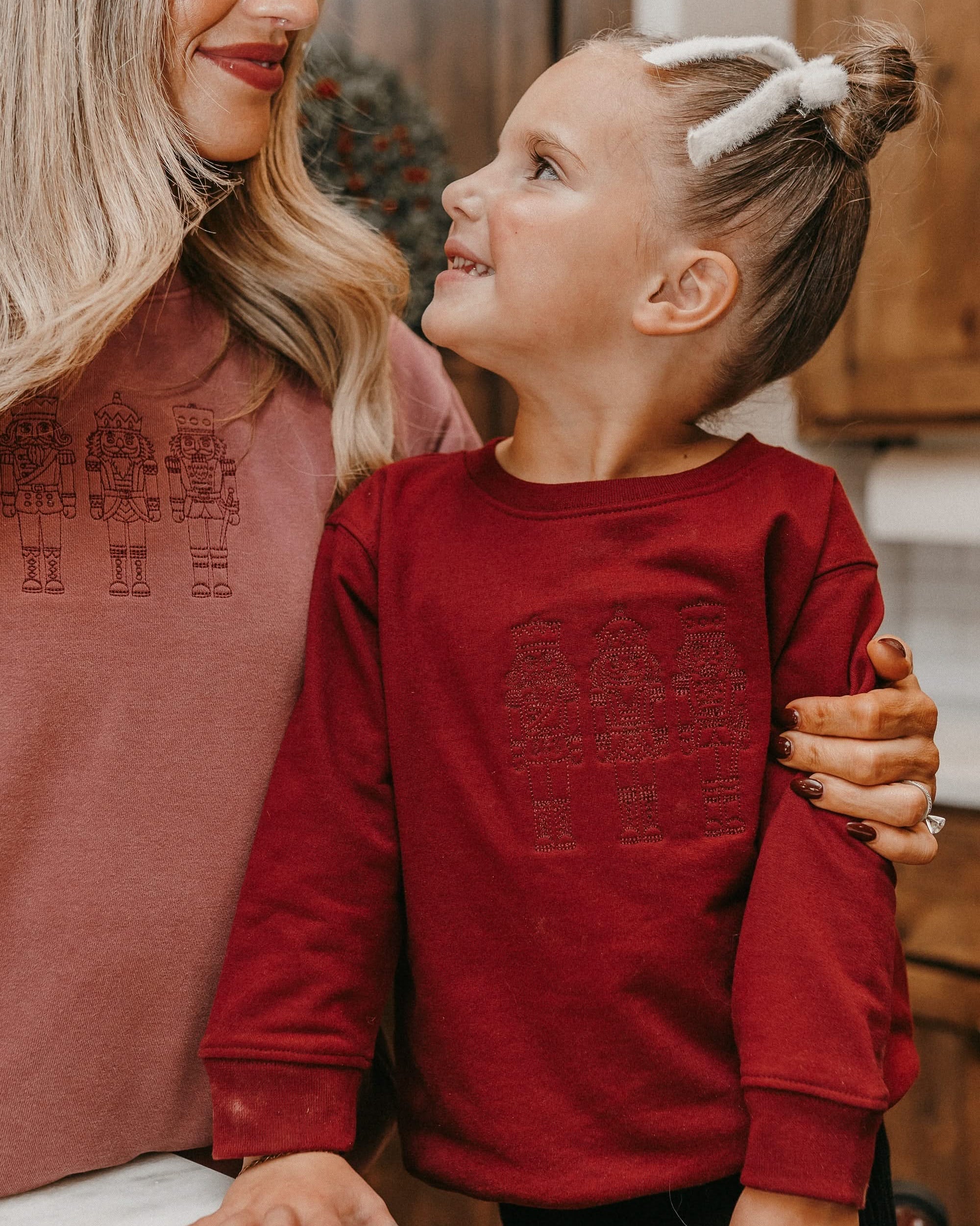 Child sweater in red with 3 embroidered nutcrackers on chest, shown on model – Little Mama Shirt Shop
