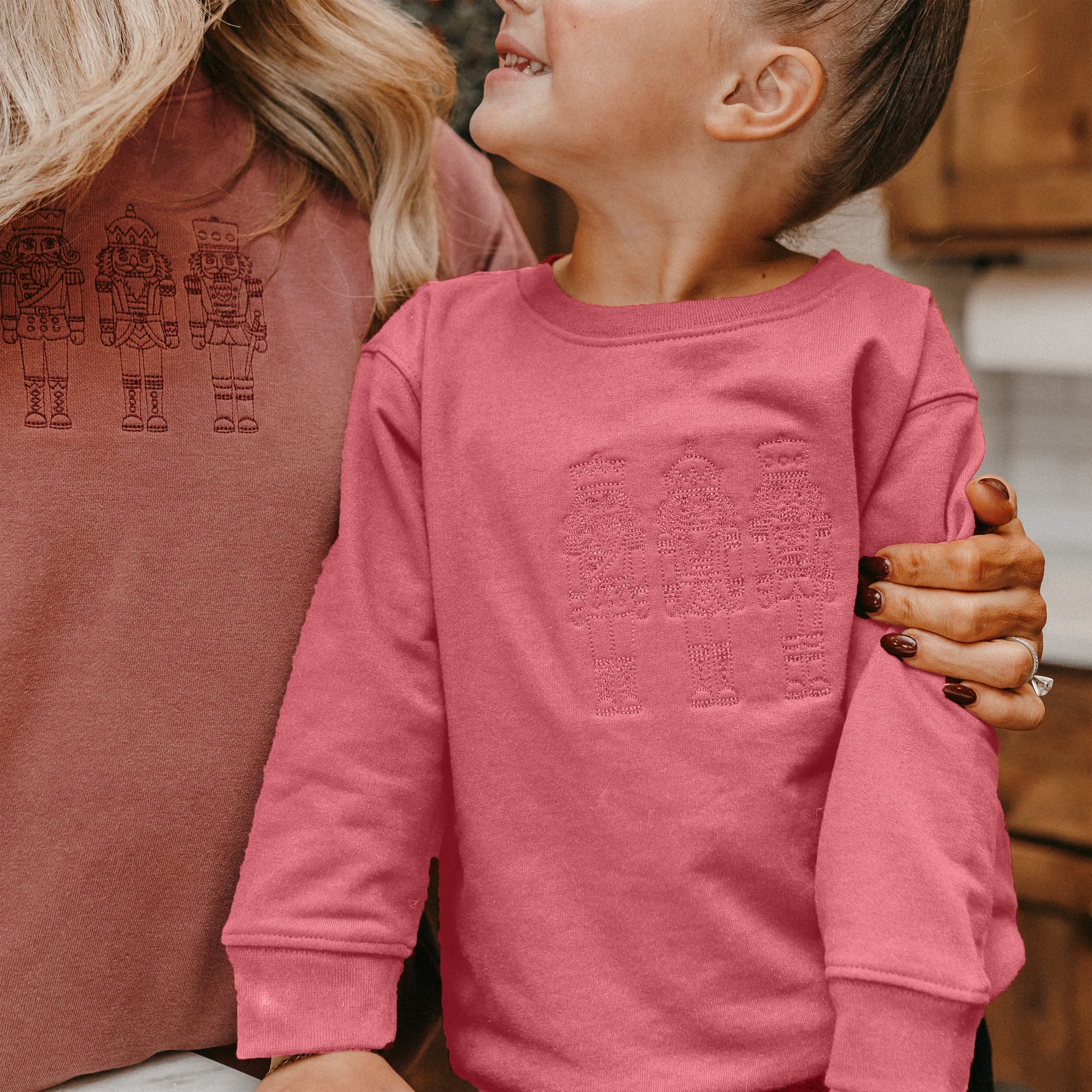 Child sweater in navy with 3 embroidered nutcrackers on chest, shown on model – Little Mama Shirt Shop
