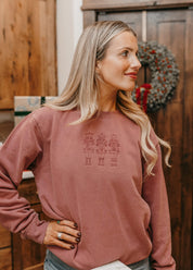 Adult sweater in dusty pink with 3 embroidered nutcrackers on chest, shown on model – Little Mama Shirt Shop