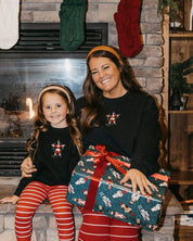Adult and child sweaters in black with Santa wrapped in lights embroidery on front, shown on models – Little Mama Shirt Shop