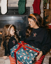 Adult and child sweaters in black with Santa wrapped in lights embroidery on front, shown on models – Little Mama Shirt Shop
