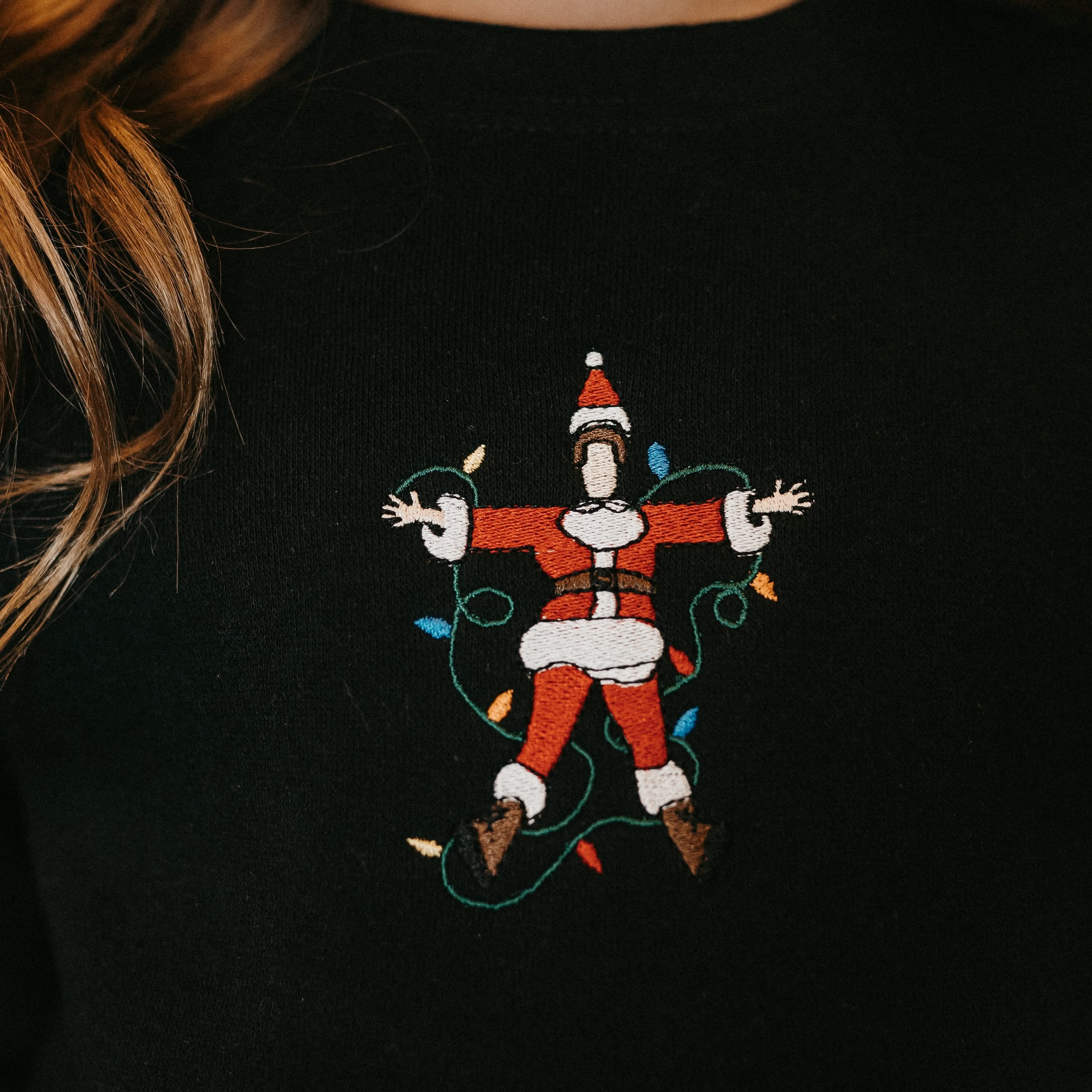 Child sweater in black with Santa wrapped in lights embroidery on front, shown on model – Little Mama Shirt Shop