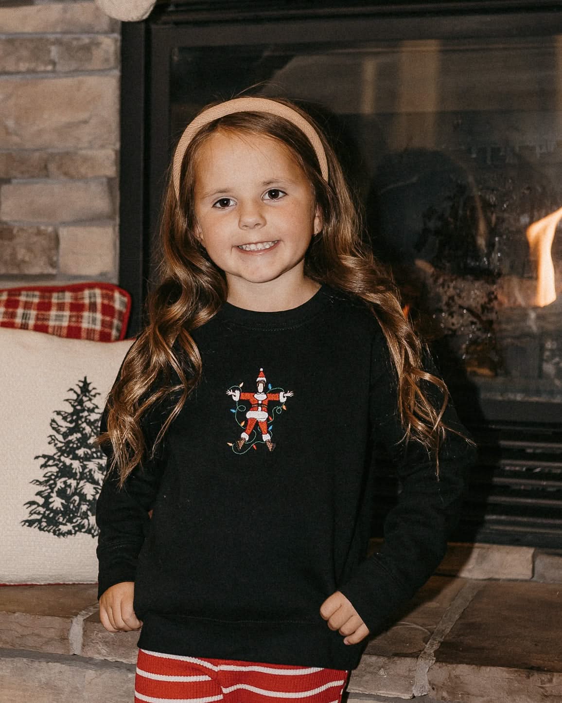 Child sweater in black with Santa wrapped in lights embroidery on front, shown on model – Little Mama Shirt Shop