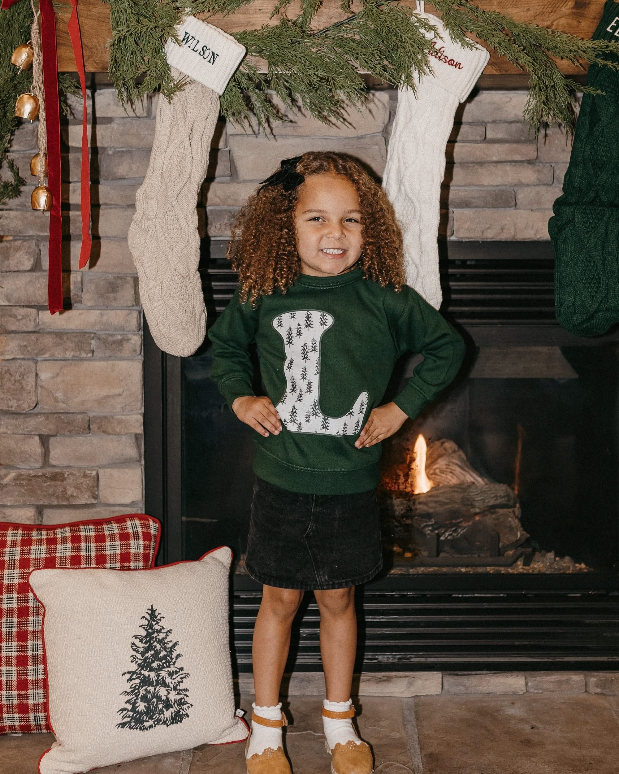 Child long sleeve in forest with Christmas patterned trees initial L on front, shown on model – Little Mama Shirt Shop
