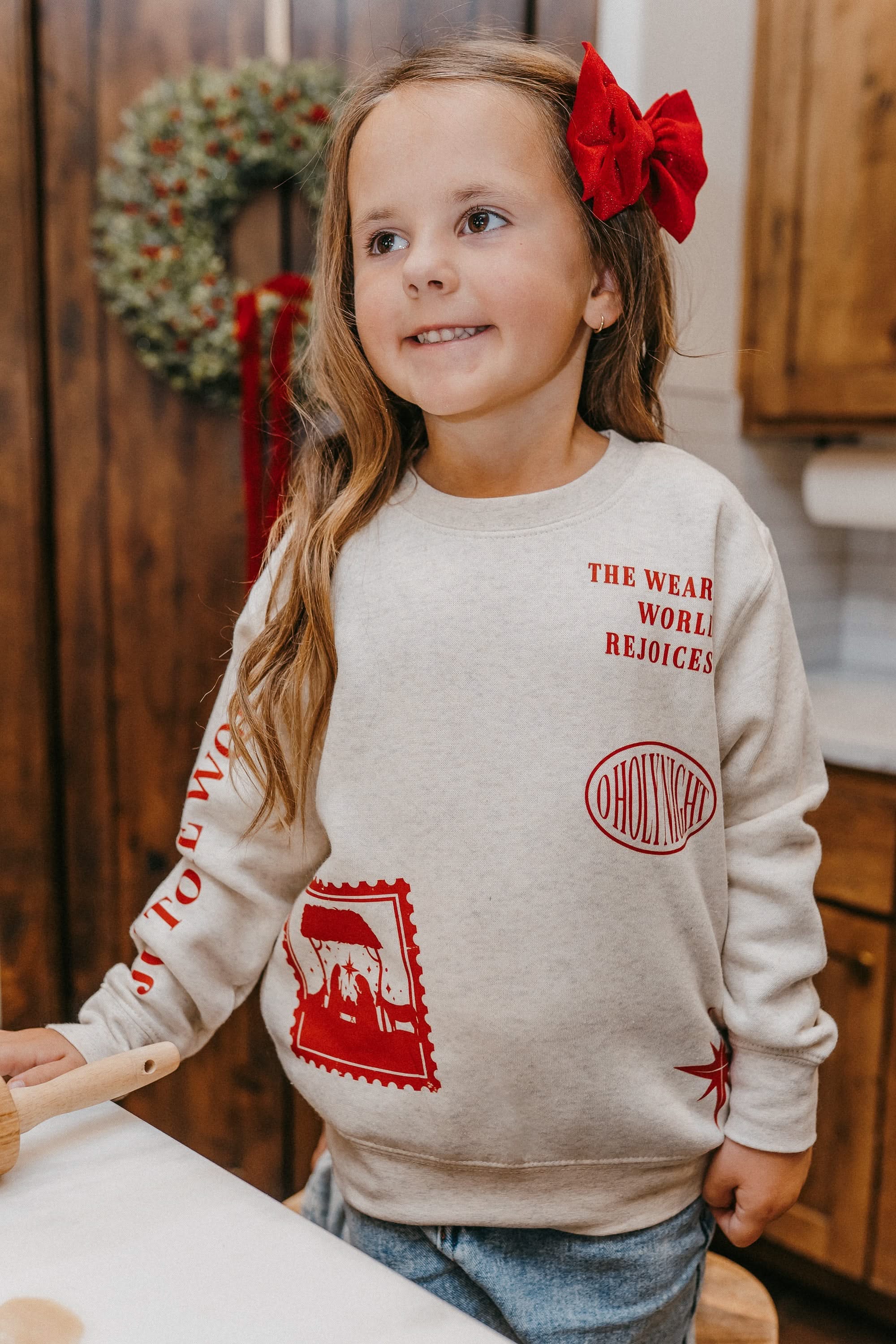 Child sweater in natural with Christian Christmas graphics on the front, shown on model – Little Mama Shirt Shop