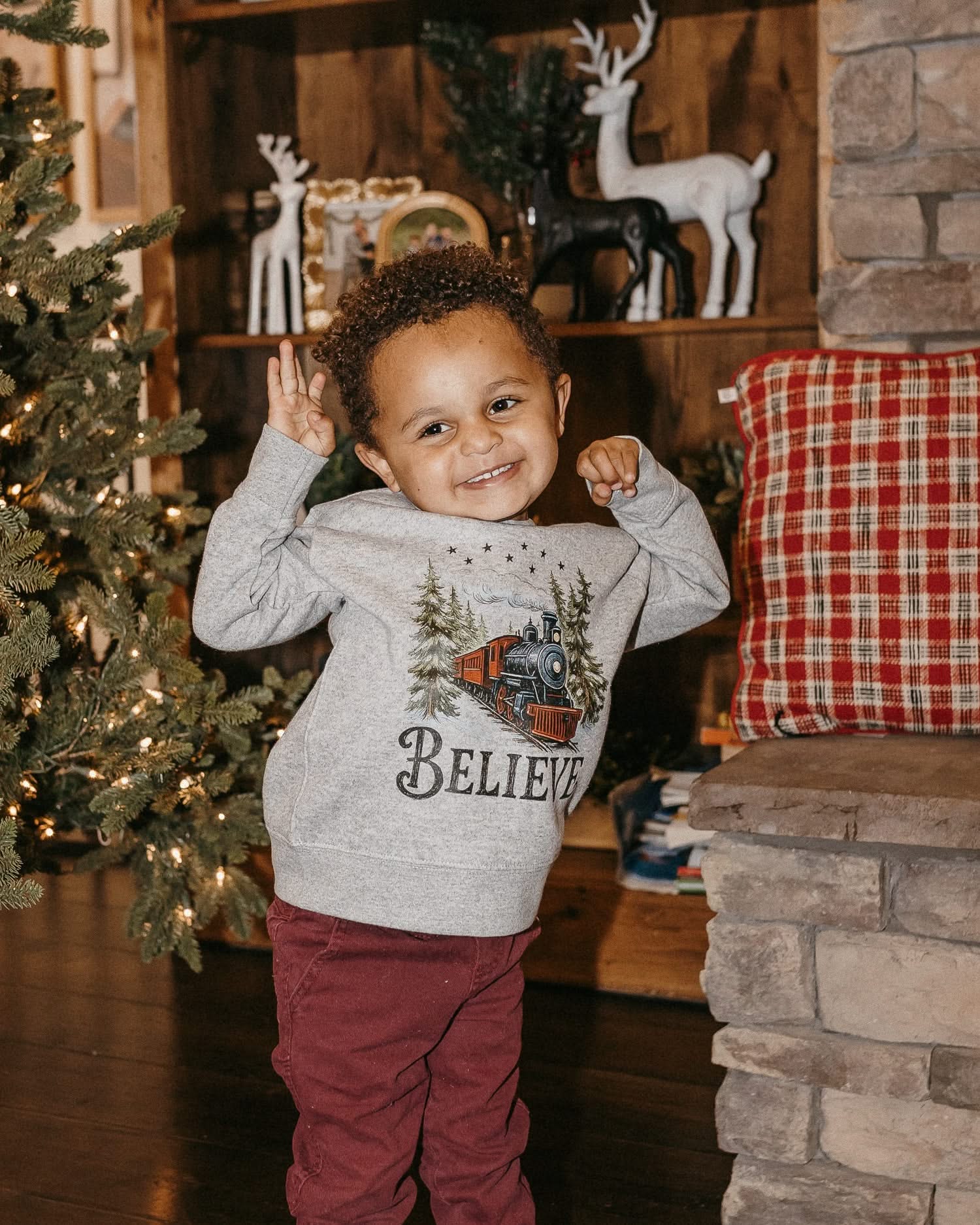 Child sweater in gray with winter train and 'Believe' on chest, shown on model – Little Mama Shirt Shop
