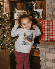 Child sweater in gray with winter train and 'Believe' on chest, shown on model – Little Mama Shirt Shop