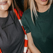 Adult tee in forest and dark gray with Christmas messages on front, shown on model – Little Mama Shirt Shop