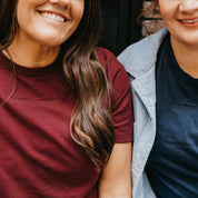 Adult tee in maroon and navy with Christmas messages on front, shown on model – Little Mama Shirt Shop