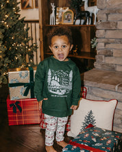 Child sweater in forest with St. Nick's Christmas Tree Farm graphic on the front, shown on model – Little Mama Shirt Shop