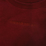 Adult tee in maroon with Christmas message on front, shown on flat lay – Little Mama Shirt Shop