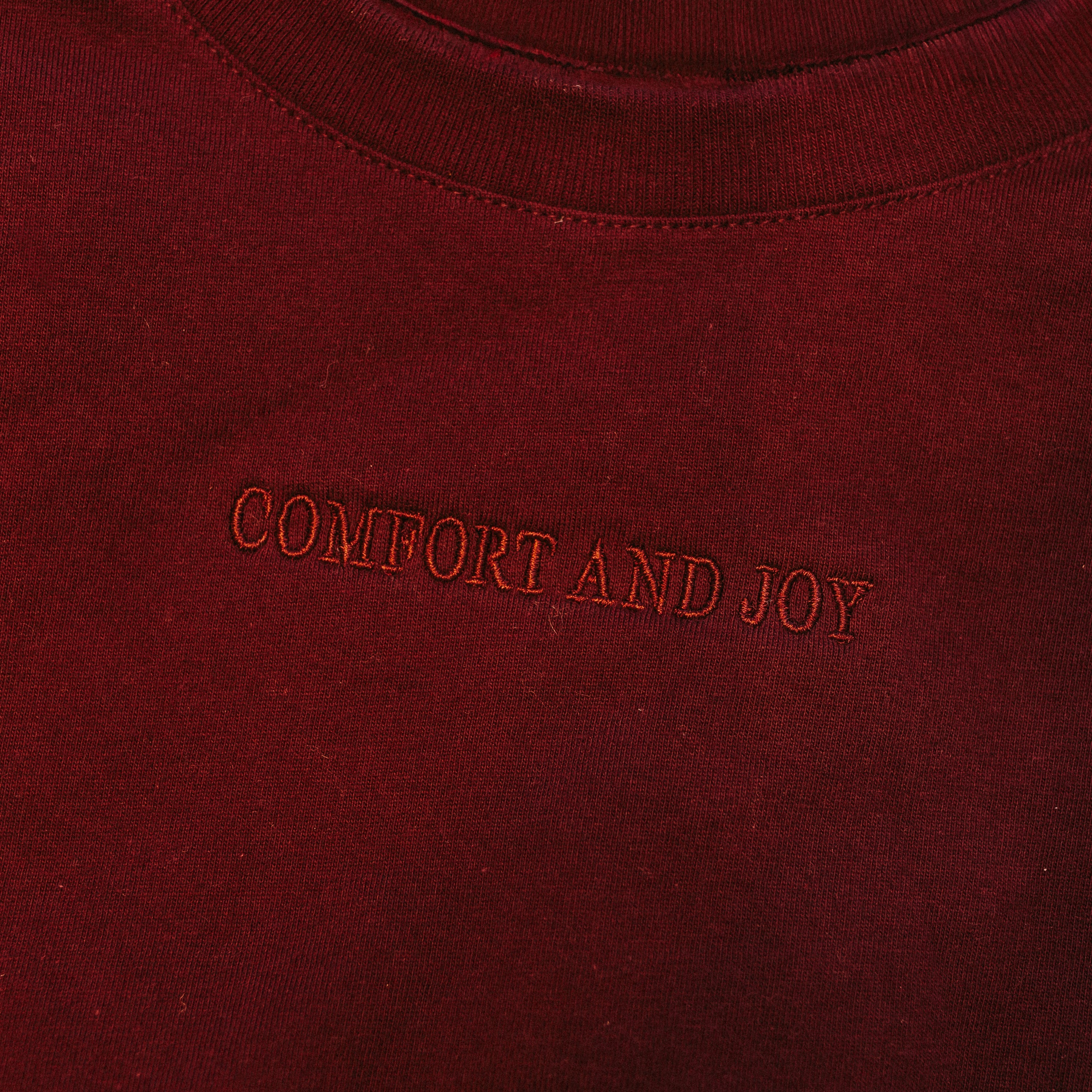 Adult tee in maroon with Christmas message on front, shown on flat lay – Little Mama Shirt Shop