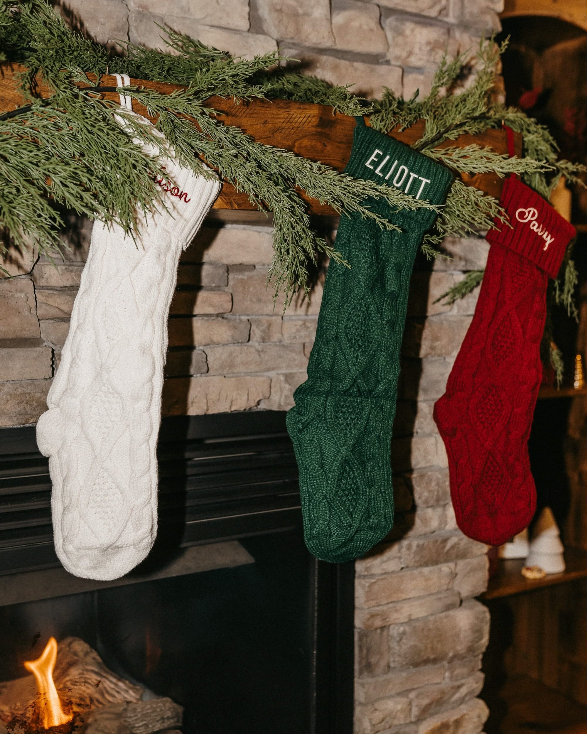 Christmas stocking in cream, red, and green with personalized name printed on cuff, shown on flat lay – Little Mama Shirt Shop
