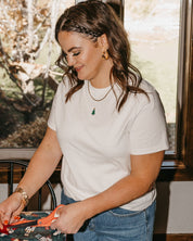 Adult tee in vintage white with Christmas mini symbol Christmas tree on front, shown on model – Little Mama Shirt Shop