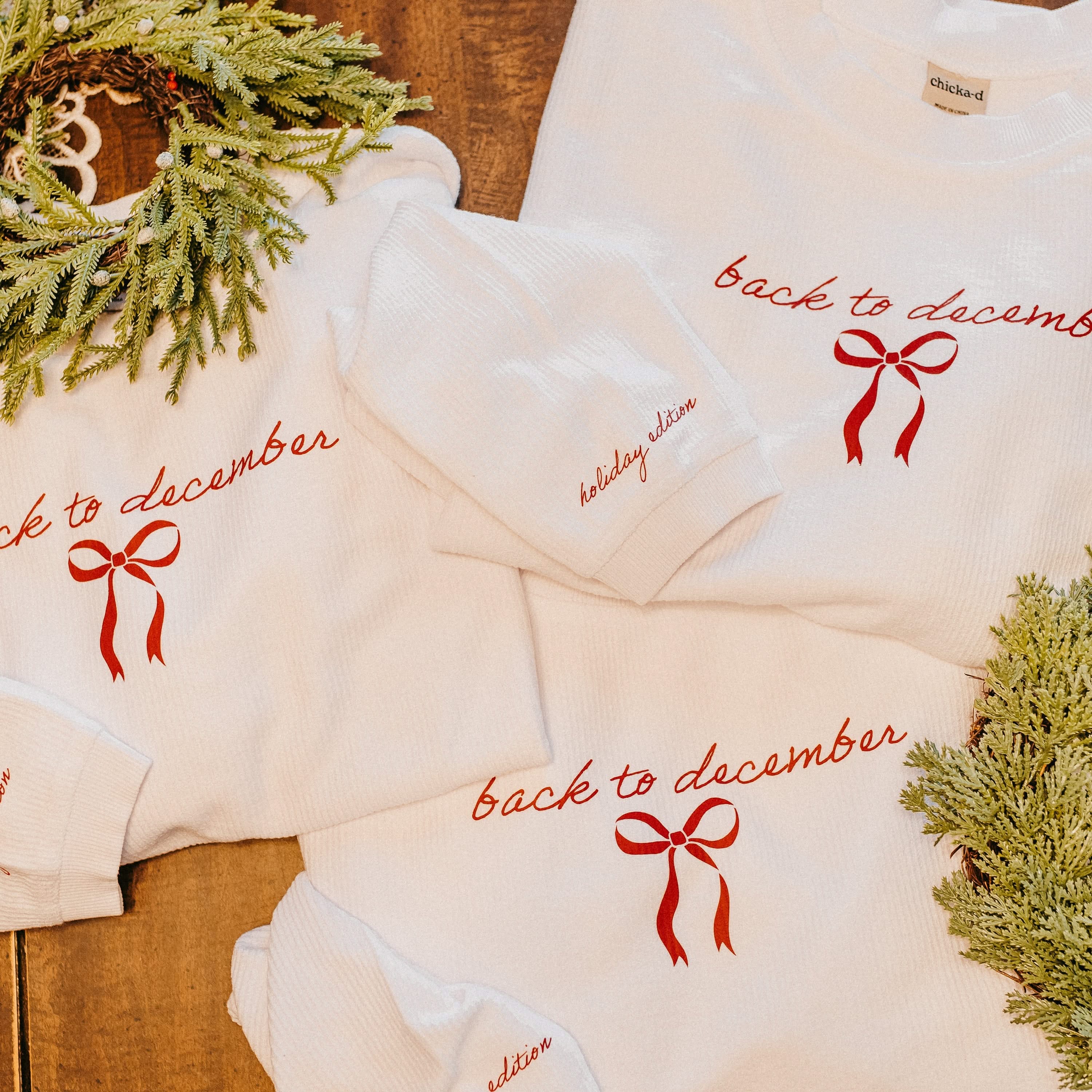 Adult sweater in white with 'back to December' and bow on chest as well as 'holiday edition' on sleeve, shown on flat lay – Little Mama Shirt Shop