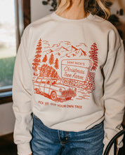 Adult basic fleece in sand with St. Nick's Christmas Tree Farm graphic on the front, shown on model – Little Mama Shirt Shop