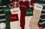 Christmas stocking in tan, cream, red, and green with personalized name printed on cuff, shown on flat lay – Little Mama Shirt Shop