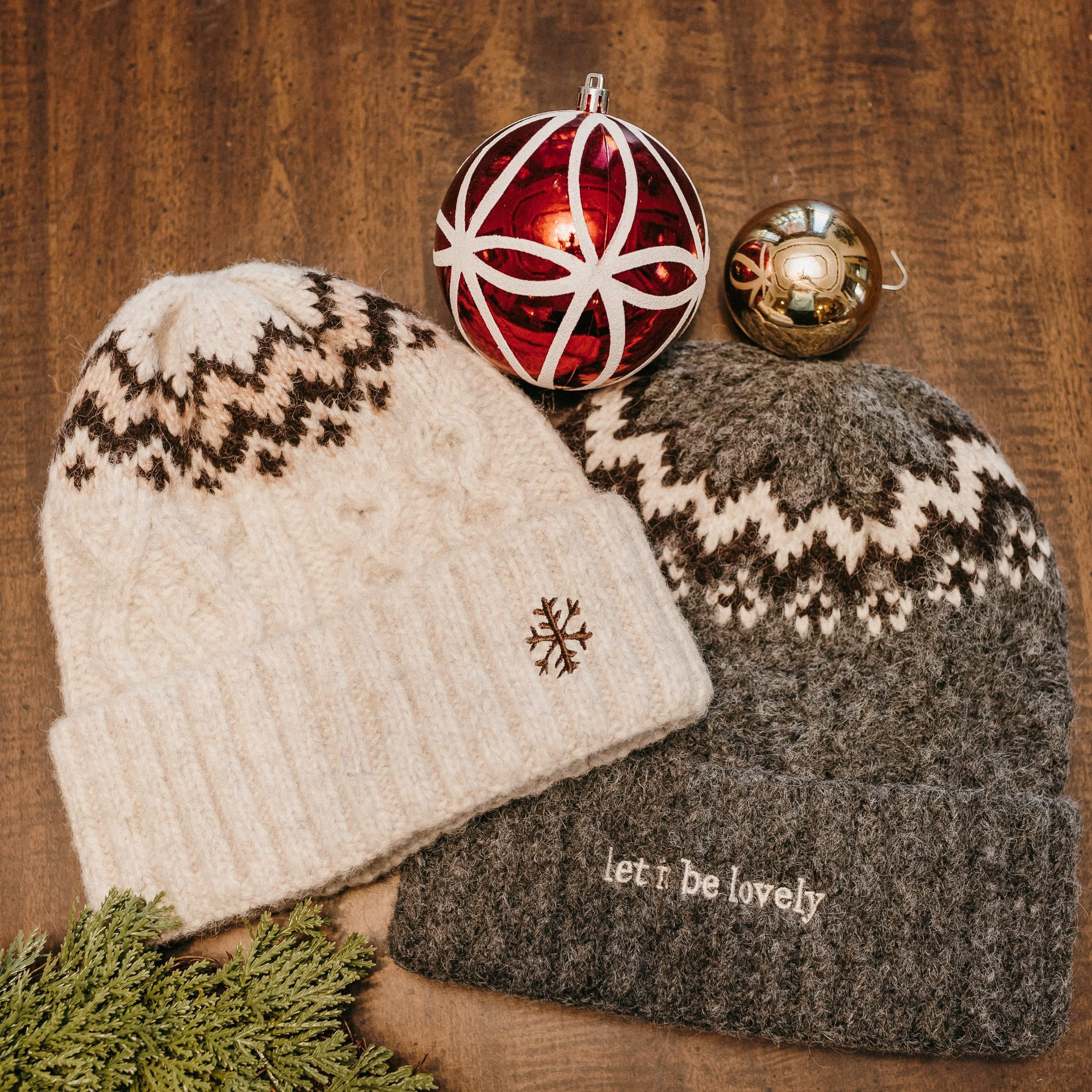 Adult beanies in cream and gray with snowflake and 'let it be lovely' designs on brim, shown on flat lay – Little Mama Shirt Shop