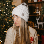 Adult beanie in cream with snowflake design on brim, shown on model– Little Mama Shirt Shop