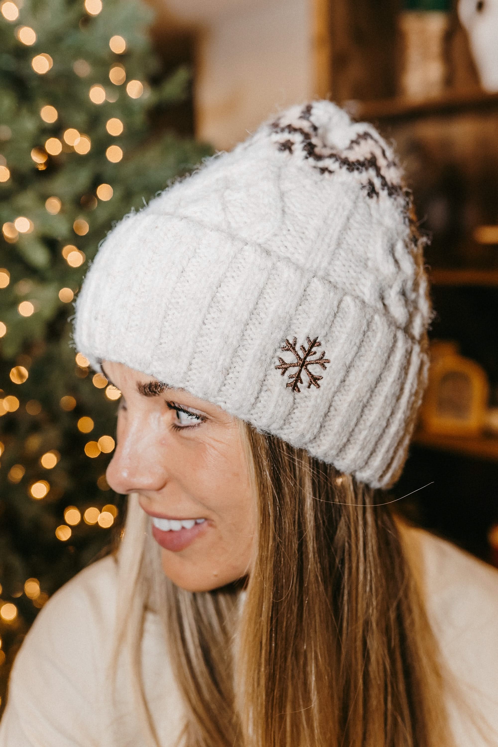 Adult beanie in cream with snowflake design on brim, shown on model– Little Mama Shirt Shop