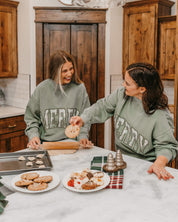 Adult mock neck sweater in green with 'Merry' graphic, shown on models – Little Mama Shirt Shop