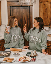 Adult mock neck sweater in green with 'Merry' graphic, shown on models – Little Mama Shirt Shop