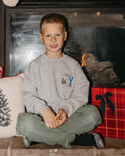 Child sweater in gray with embroidered ski pattern, shown on model – Little Mama Shirt Shop