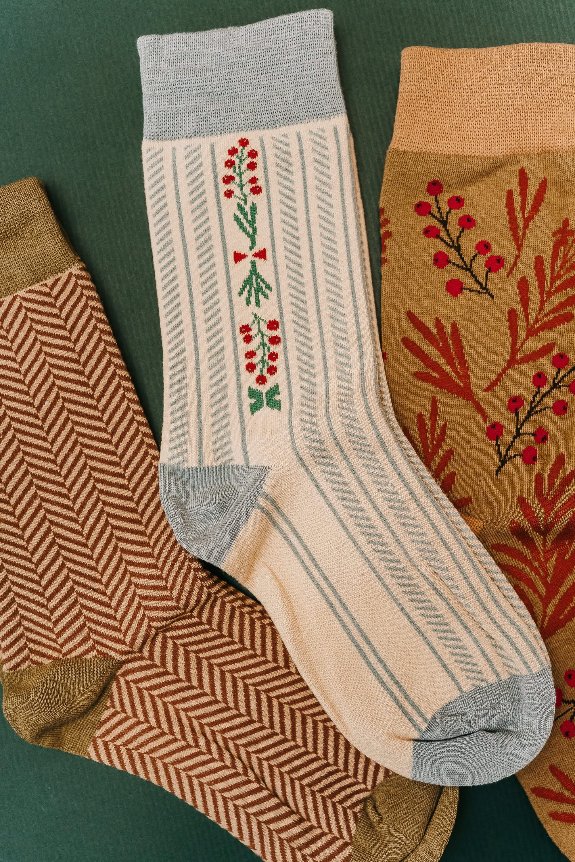 Adult socks in brown/green, cream/blue, and brown/green with chevron and holly patterns, shown on flat lay – Little Mama Shirt Shop