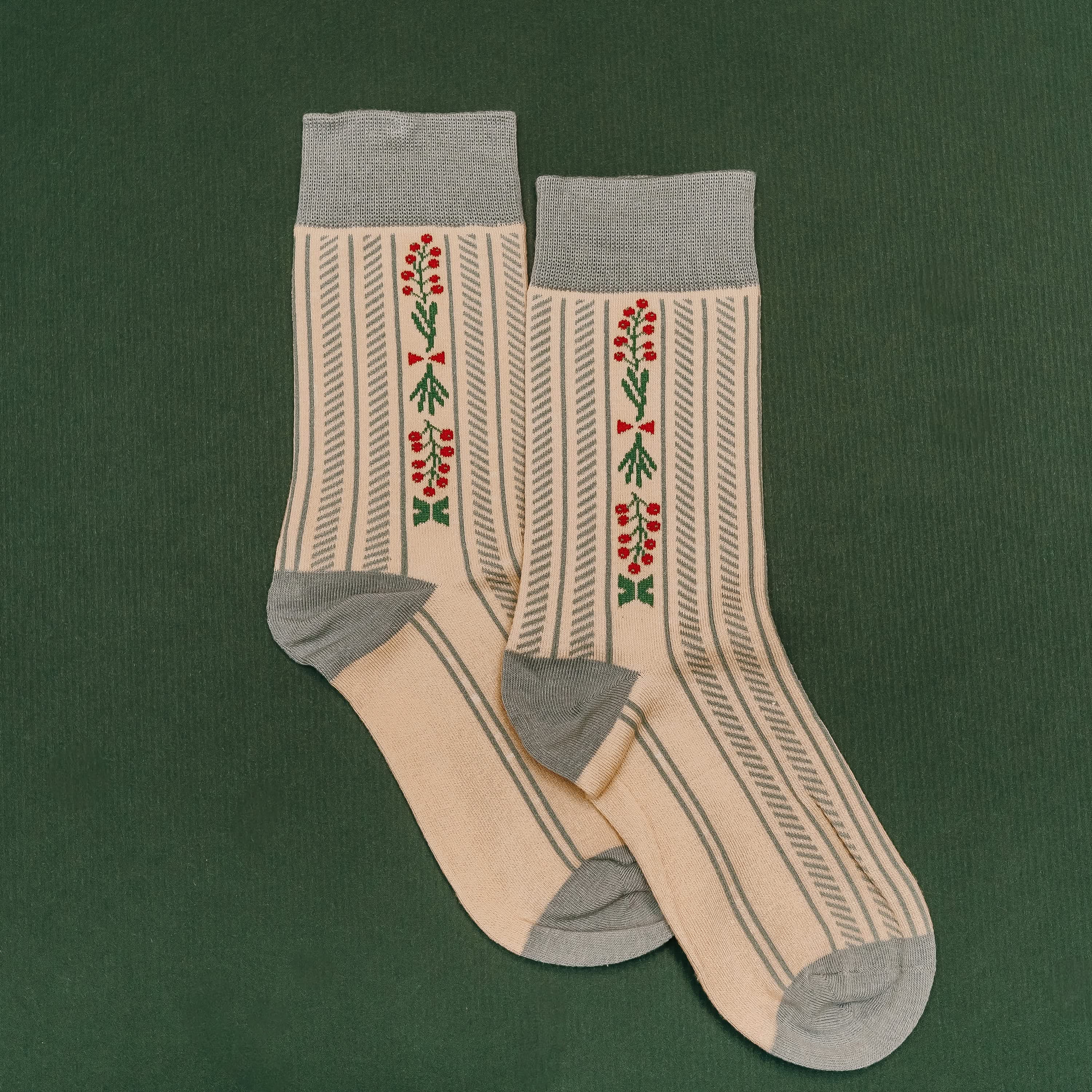 Adult socks in cream/blue with holly pattern, shown on flat lay – Little Mama Shirt Shop