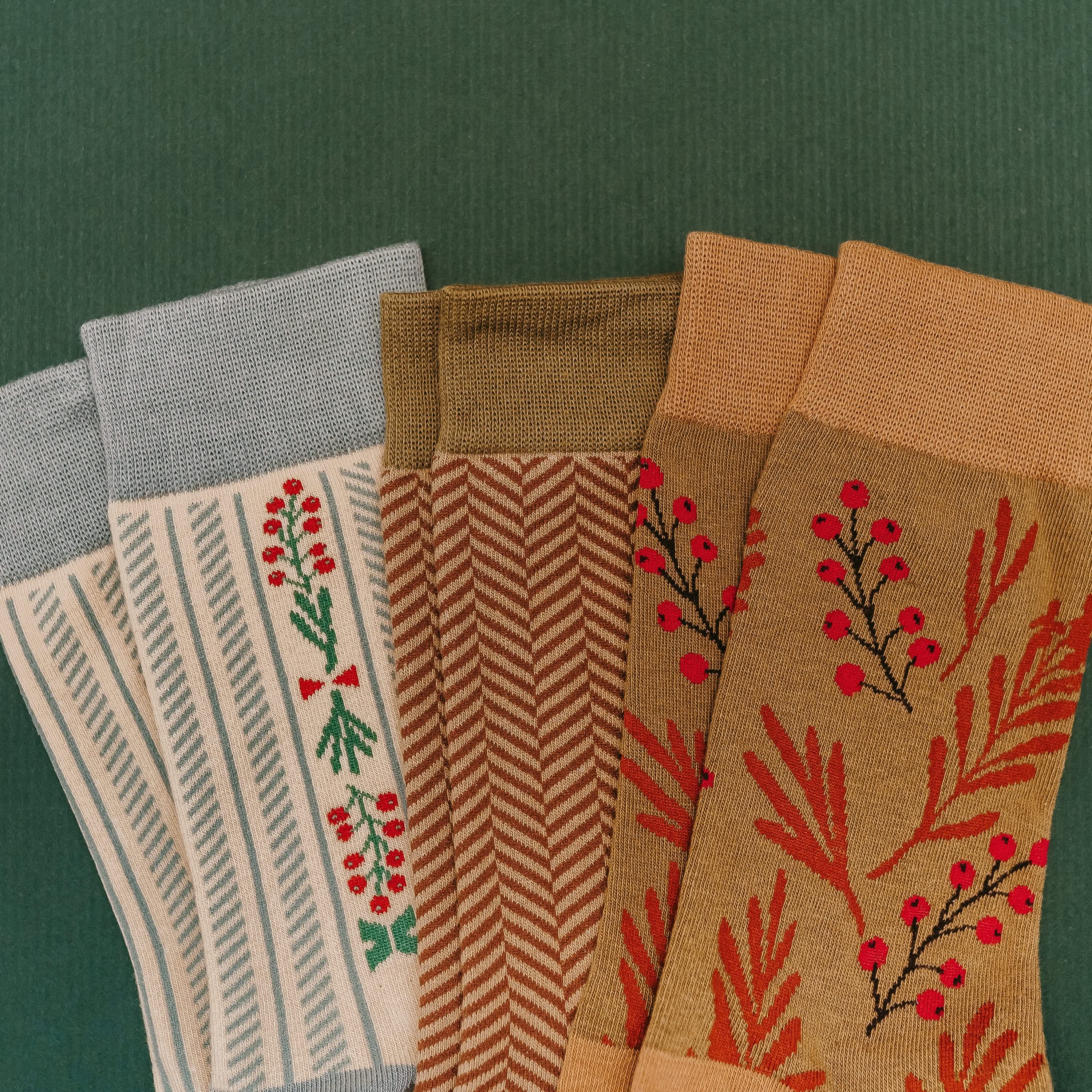 Adult socks in brown/green, cream/blue, and brown/green with chevron and holly patterns, shown on flat lay – Little Mama Shirt Shop