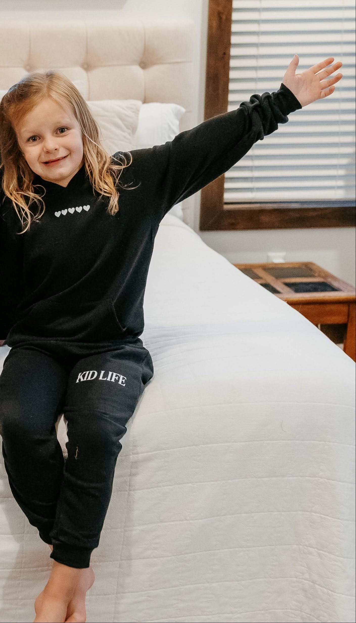 Kids hoodie and jogger in black with white hearts on chest and 'Kid Life' on leg of joggers on model - Little Mama Shirt Shop