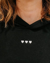 Hoodie chest close up black with white with three embroidered hearts on model - Little Mama Shirt Shop