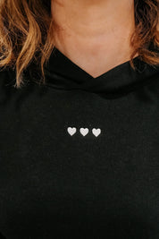 Hoodie chest close up black with white with three embroidered hearts on model - Little Mama Shirt Shop