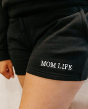 Short close up in black with white embroidered  'Mom Life' graphic on model - Little Mama Shirt Shop