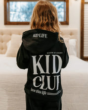 Hoodie back view in black with white 'Kid Club' graphic on model - Little Mama Shirt Shop