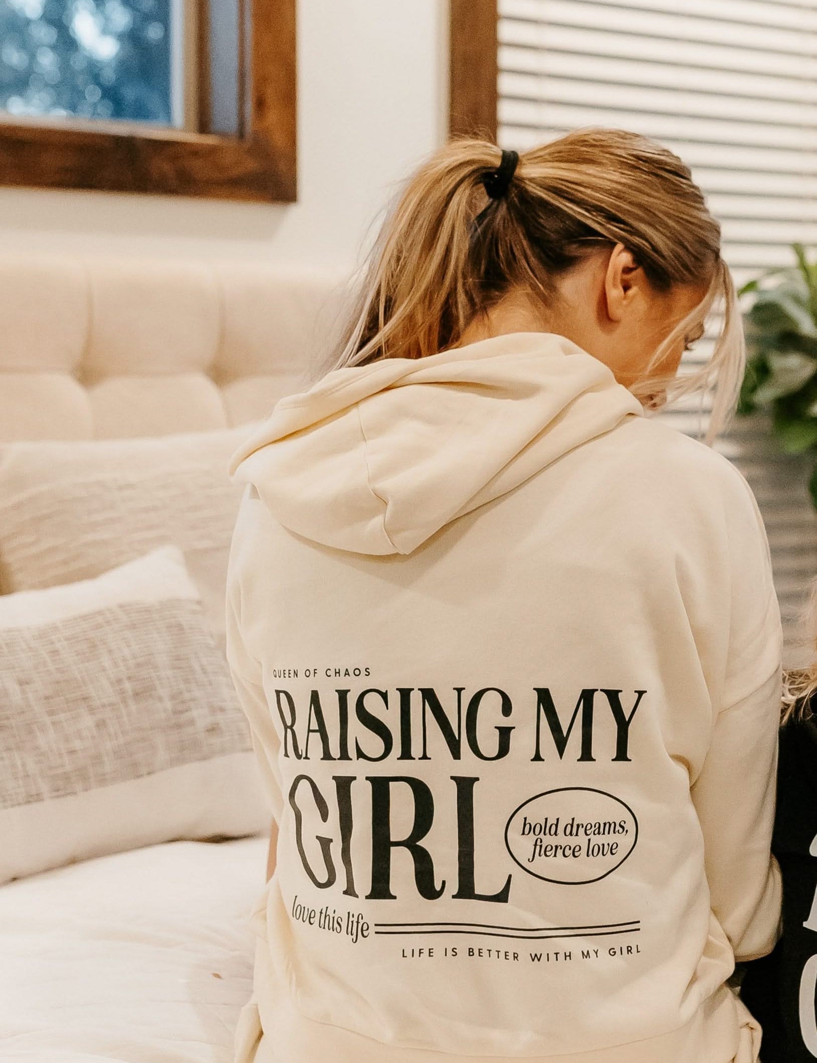 Hoodie in bone with black 'Raising My Girl' graphic on model - Little Mama Shirt Shop