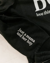 Hoodie sleeve close up black with white  embroidered 'just a mama and her boy' on flat lay - Little Mama Shirt Shop
