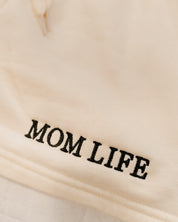 Short close up in bone with black embroidered  'Mom Life' graphic on model - Little Mama Shirt Shop