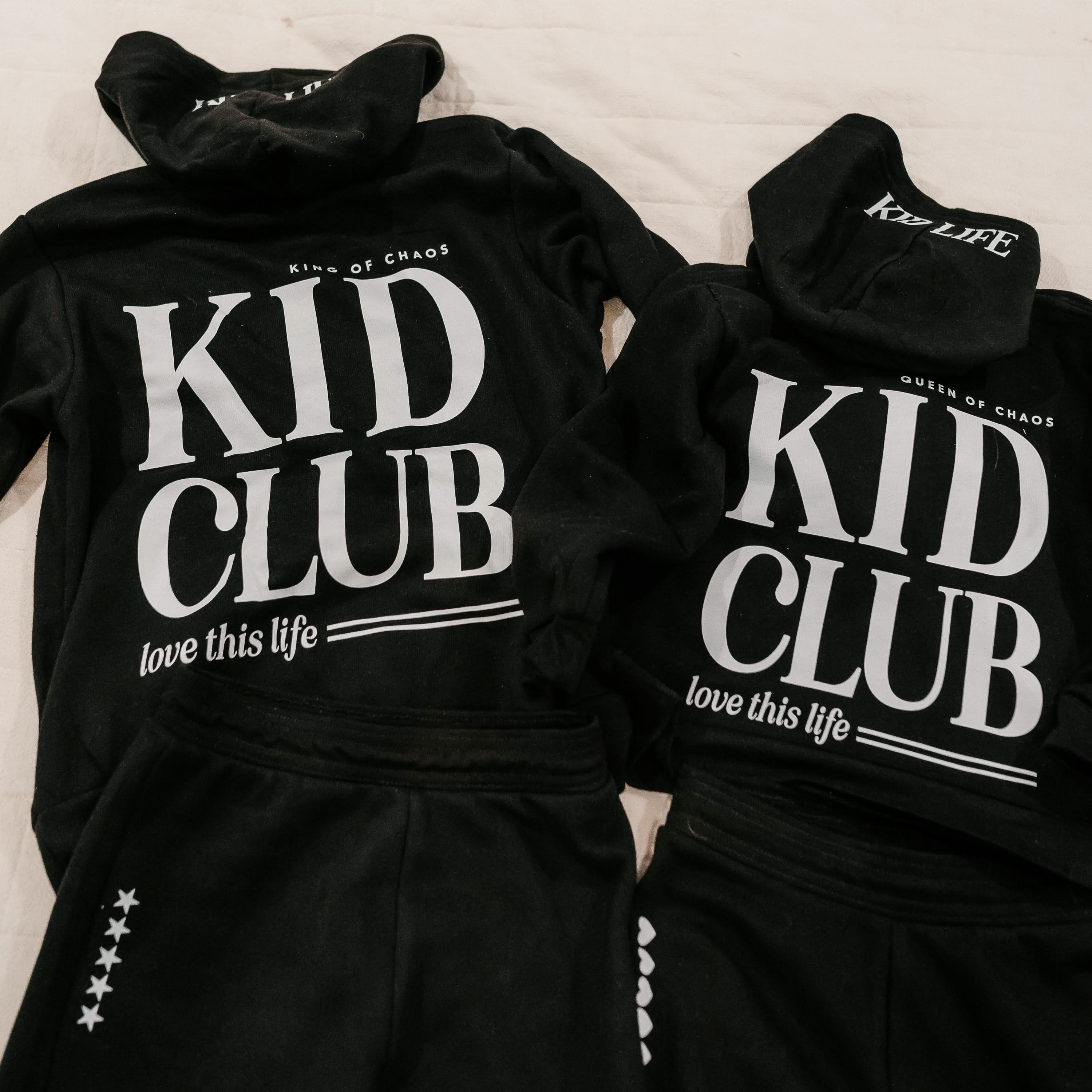 Two hoodies back view in black with white 'Kid Club' graphic on flat lay - Little Mama Shirt Shop