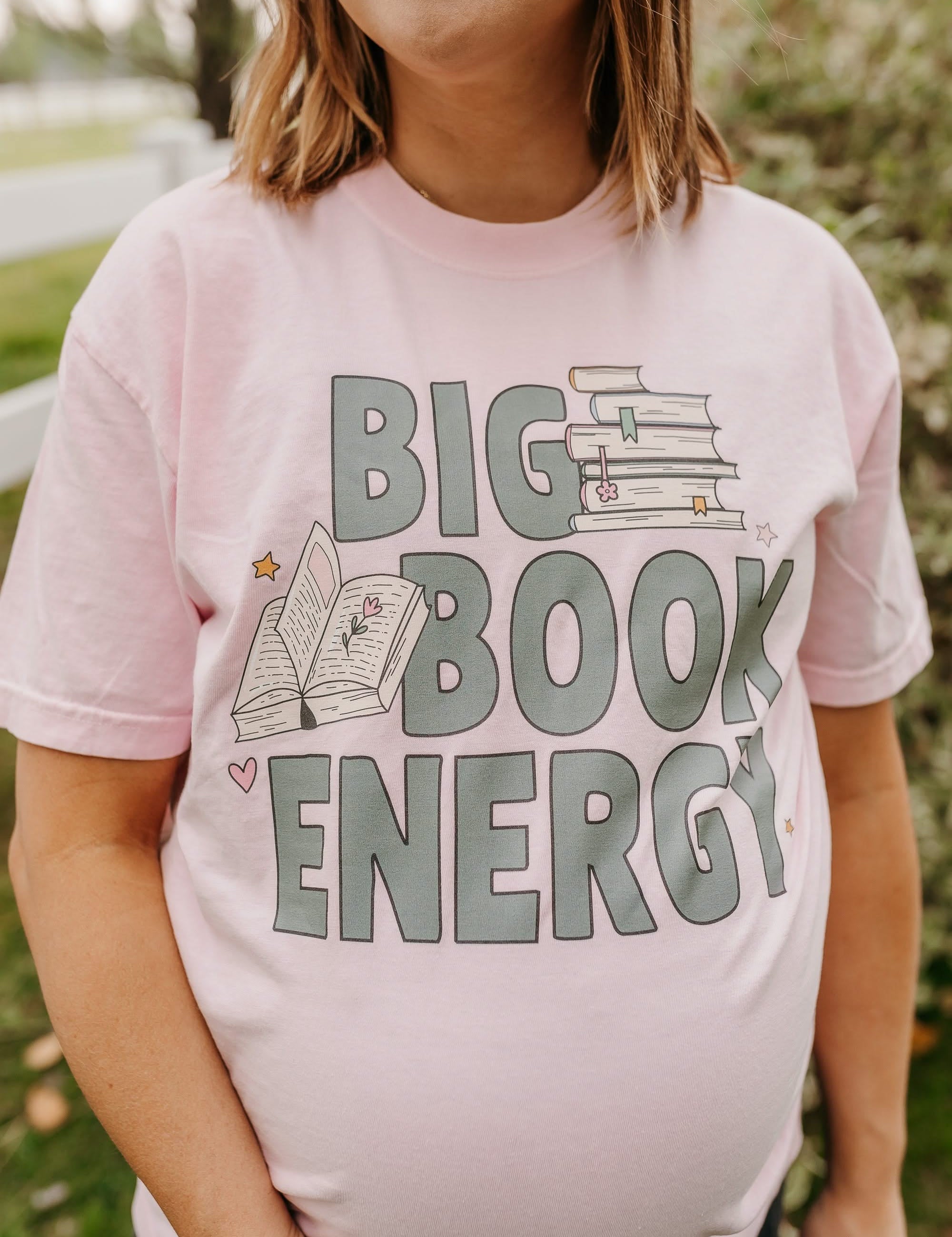 Comfort colors tee in blossom with 'Big Book Energy' graphic, shown on model – Little Mama Shirt Shop