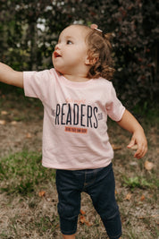 Child’s t-shirt with “Late Night Readers Club BYOB” design in pink, on model – Little Mama Shirt Shop