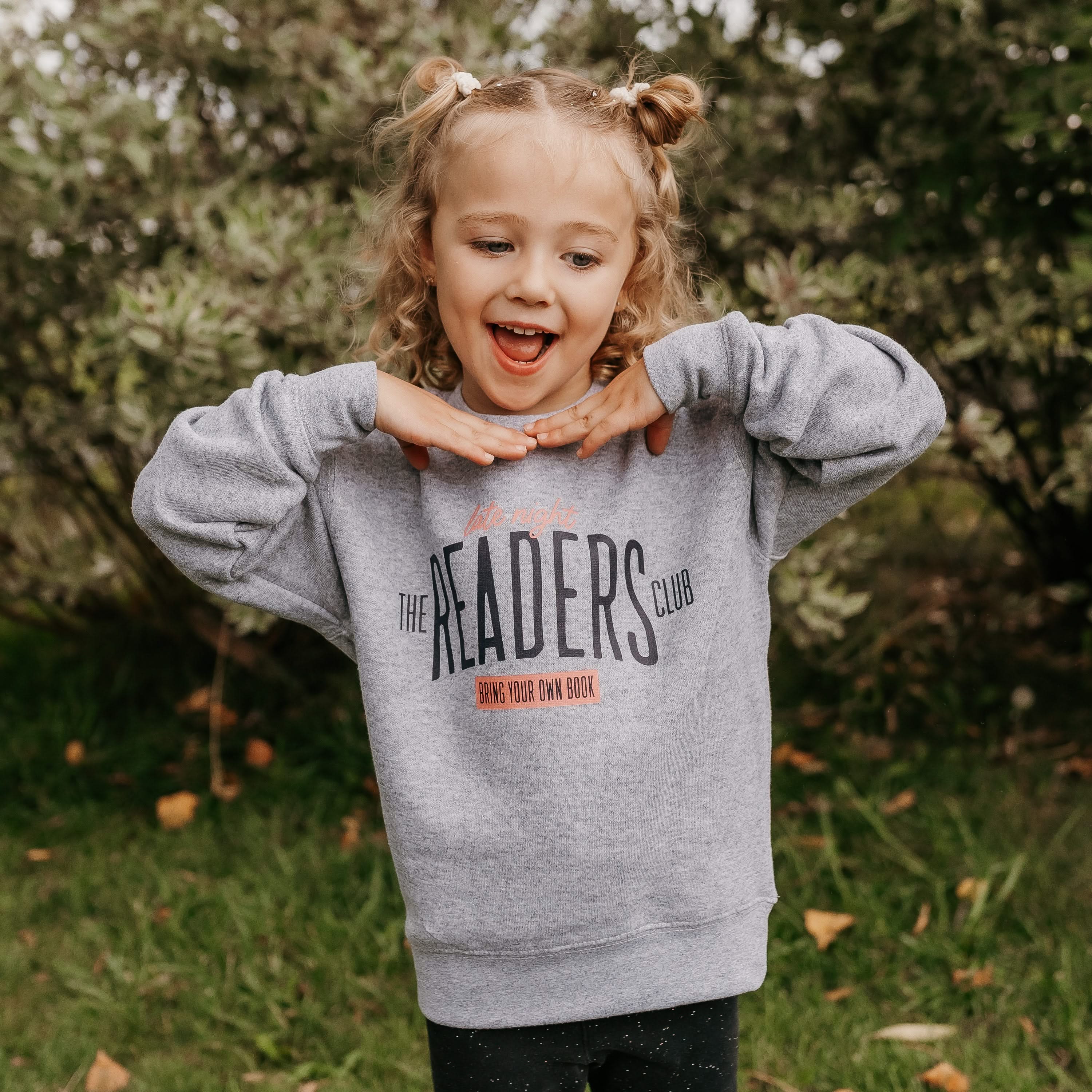 Child’s sweater with “Late Night Readers Club BYOB” design in gray, on model – Little Mama Shirt Shop