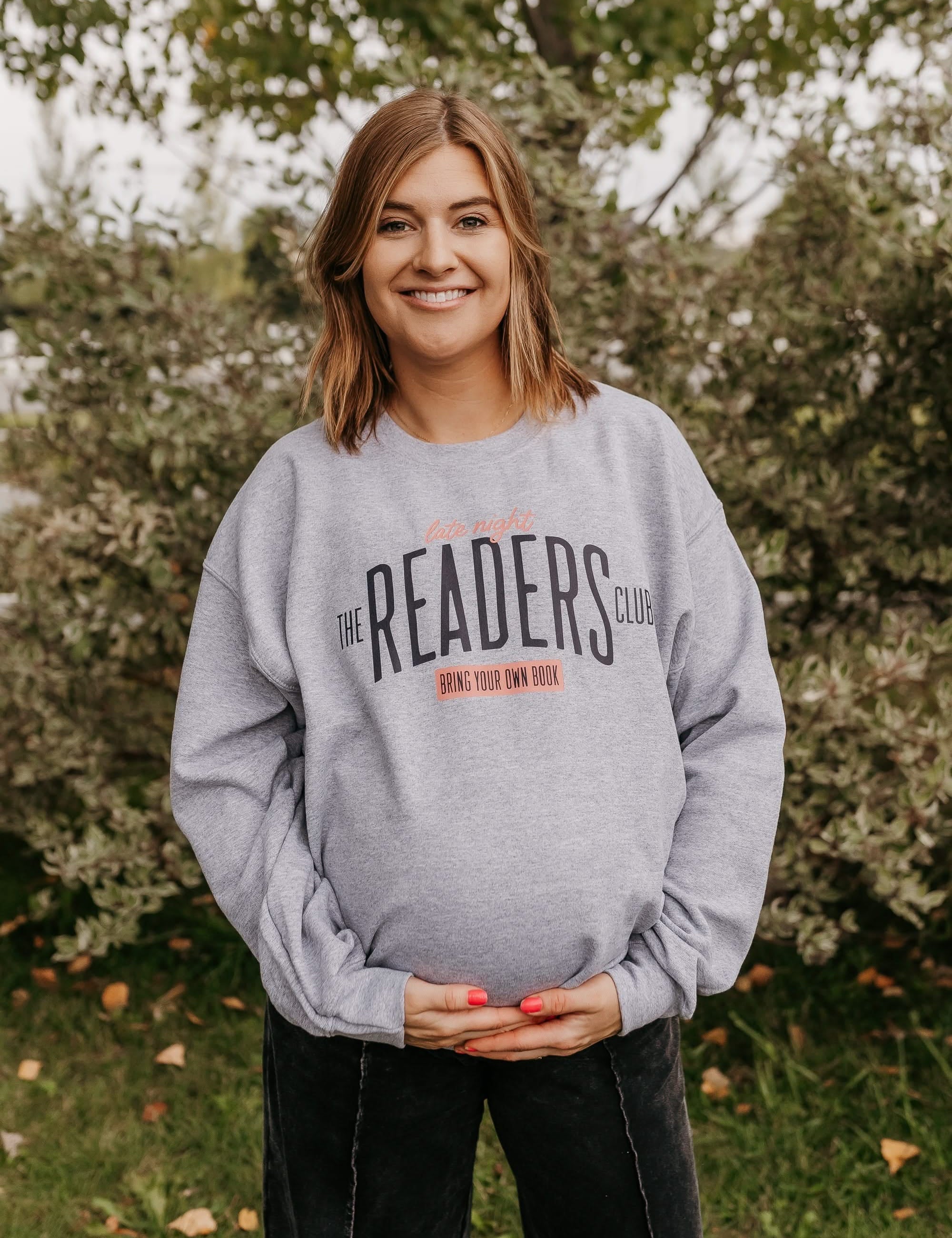 Unisex fleece sweatshirt in gray with “Late Night Readers Club BYOB” design on model – Little Mama Shirt Shop