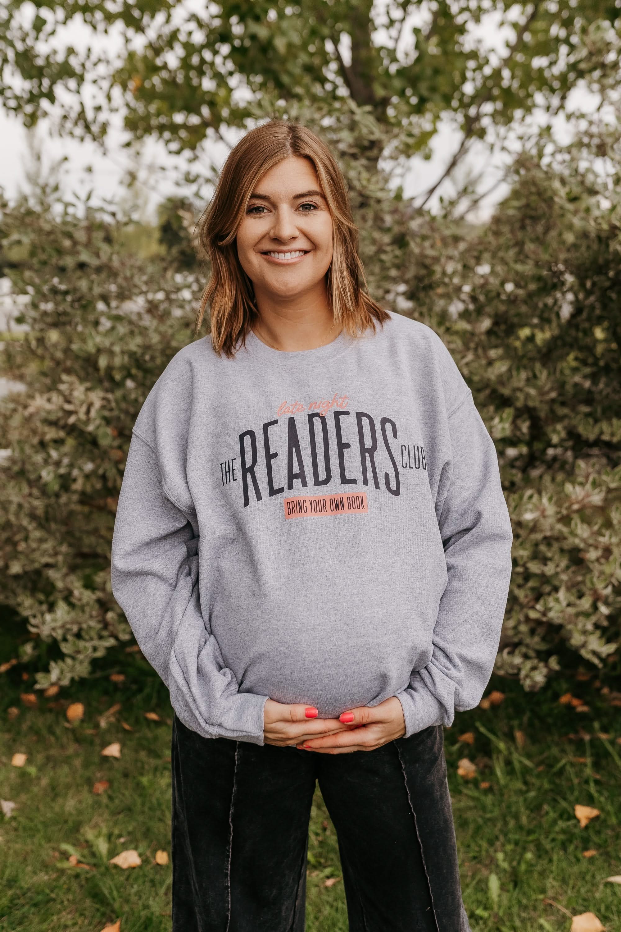 Unisex fleece sweatshirt in gray with “Late Night Readers Club BYOB” design on model – Little Mama Shirt Shop