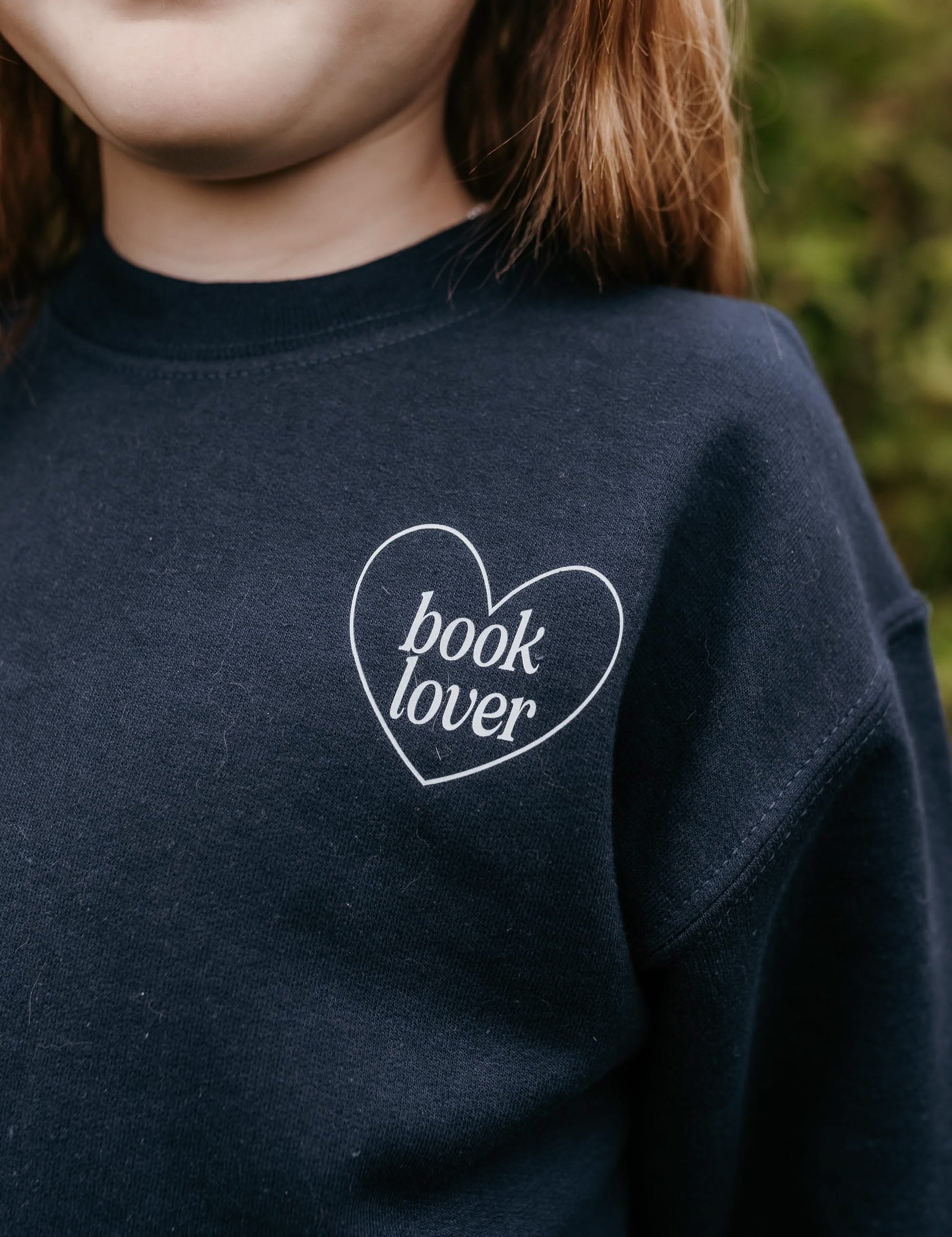  light blue detail with a 'book lover' heart graphic on the front and 'What are you reading?' graphic on back, shown on model – Little Mama Shirt Shop