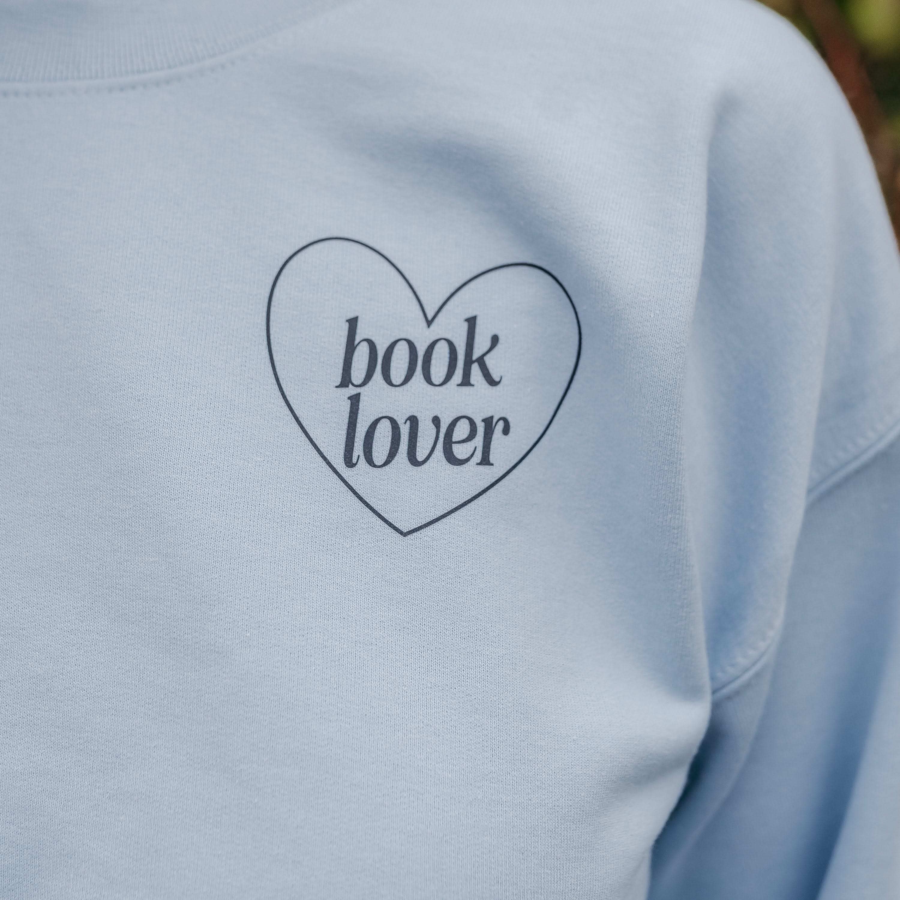  navy detail with a 'book lover' heart graphic on the front and 'What are you reading?' graphic on back, shown on model – Little Mama Shirt Shop
