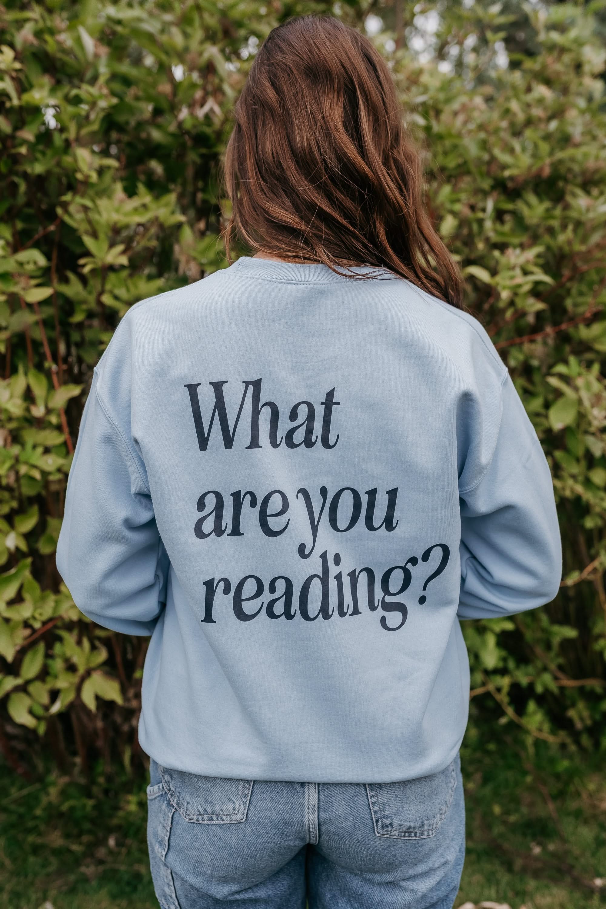 Basic Fleece in light blue w/ navy detail with a 'book lover' heart graphic on the front and 'What are you reading?' graphic on back, shown on model – Little Mama Shirt Shop