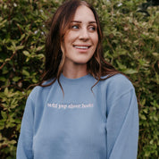 Embroidered “Will Yap About Books” pigment-dyed crewneck in light blue with pink thread on model  – Little Mama Shirt Shop