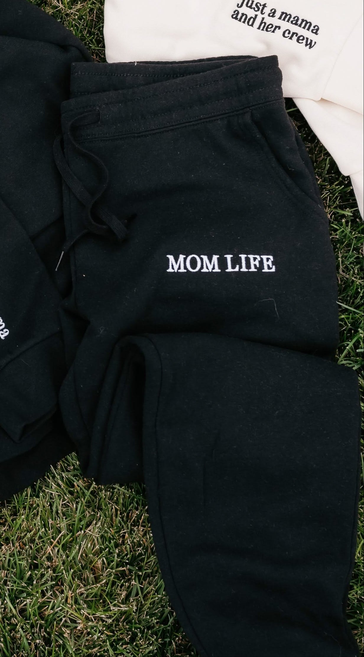 Joggers in black and white with 'Mom Life' embroidery on flat lay - Little Mama Shirt Shop
